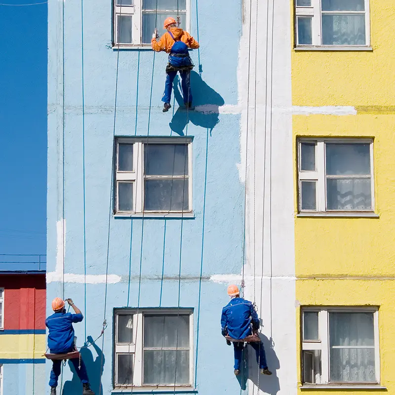 Maler streichen Hauswand bunt